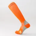 Dettaglio di calze a compressione sportiva arancione con tallone rinforzato e texture antiscivolo. - Arancione
