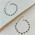 Vista dettagliata di bracciali in acciaio inossidabile oro e argento con cuori neri - Oro / Nero