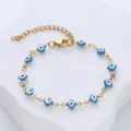 Detailed view of the golden stainless steel bracelet with blue evil eye enamel charms. - Lake Blue