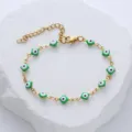 Detail view of a Turkish Evil Eye gold stainless steel bracelet with green enamel charms. - Green