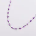 Dettaglio di una collana in acciaio inossidabile con ciondoli a mano di Hamsa viola - Viola