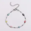 Primo piano dettagliato di un braccialetto Hamsa in acciaio inox con sette malocchi colorati - Multicolore