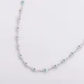 Dettaglio ravvicinato della collana mano di Hamsa in acciaio inox e smalto blu - Bianco
