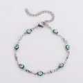 Vista dettagliata di un bracciale Hamsa in acciaio inossidabile con ciondoli malocchio verdi - Oro / Verde