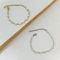 Dettaglio di bracciali a cuore in acciaio inossidabile con finitura in smalto bianco a goccia - Oro / Bianco