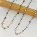 Vue détaillée des colliers en émail Evil Eye sur un présentoir en bois naturel - Perles Multicolores Couleur Acier / 45+5cm / Acier