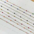 Primo piano di perle di smalto colorato su una catena d'oro in acciaio inossidabile - Perline Multicolore / Oro