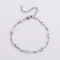 Vista dettagliata del bracciale mano di Hamsa in acciaio inox con ciondoli malocchio - Oro / Bianco