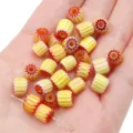 Hand holding 8mm yellow and orange striped Millefiori glass barrel beads for DIY jewelry - 8mm Hole Approx 1mm 10 Pieces/Pack / Yellow