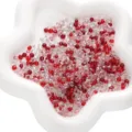 Perles de rocaille en verre de 4 mm rouges et transparentes dans un plat blanc étoilé - Série Rouge Argent