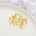 Small 14K gold filled flat spacer beads scattered on a white ceramic plate for DIY jewelry. - Triangle Center Hole Style / 10 Pieces Pack / 14K Gold