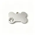 Detailed view of a polished stainless steel bone-shaped pet tag with a paw cutout. - Silver