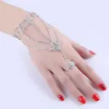 Detailed view of an elegant silver rhinestone slave bracelet with heart charms on hand model - Heart Hand Chain Bracelet / Silver