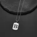 Close-up of a stainless steel necklace with a cutout letter B pendant and chain detail. - Letter B