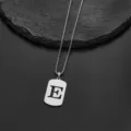 Detail of stainless steel rectangular pendant with cutout alphabet letter E - Letter E