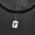 Detailed view of a stainless steel necklace with a hollow letter F cutout pendant on stone - Letter F