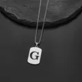 Detail view of a silver stainless steel necklace featuring an engraved letter G pendant - Letter G