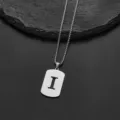 Detailed macro shot of a stainless steel necklace with a cutout letter I pendant - Letter I