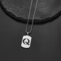Close-up of a silver stainless steel necklace with a hollowed letter Q pendant. - Letter Q