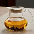 Détail d'une théière en verre avec couvercle en titane montrant du thé et des baies - 650ml / Transparent