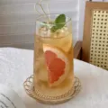 Ribbed high borosilicate glass cup filled with iced fruit tea on a bamboo coaster - 520ml / 条纹杯高款