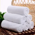 Macro view showing the soft texture of premium rolled white cotton towels for hotel or spa use - 30*70cm / 90g