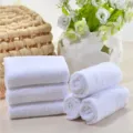 Set of pure white cotton towels rolled and stacked neatly in a spa decor setting - 30*70cm / 50 g