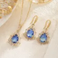 Vista detallada de conjunto de joyas con cristal azul gota, circonitas y cadena oro - Juego de Joyas (10054) / Degradado Blanco & Azul