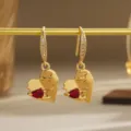 Detailed view of vintage gold heart earrings featuring pear-cut red zircon stones - Heart Style (80429) / Retro Copper