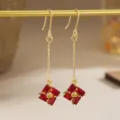 Detailed macro view of vintage gold long drop earrings featuring red zircon square pendants - Hook Earrings Style (80489) / Red