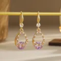 Close-up of gold-plated hollow teardrop earrings featuring pink zircon crystal stones - Hollow Drip Style (80431) / Pink