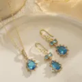 Detailed view showing the sparkling blue teardrop pendant and matching earrings set. - Water Drop Style (80104) / Necklace and Earring Set / Sea Blue / Gold