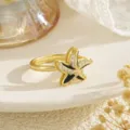 Close-up detail of a gold-plated starfish rotating ring with black enamel and zircons - Double Sea Star Style (80391) / Gold