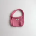 Close-up detail of a soft pink knitted hobo bag featuring a small egg brand label - 19*14 / Pink