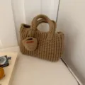 Detailopname van de textuur van een handgemaakte bruine katoenen gehaakte handtas met hartbedel - Kaki