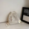 Witte gebreide rugzak met trekkoord en bloemendecoratie in een minimalistische setting - Gebreide Trekkoord Bloemenstijl / Beige