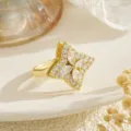 Macro view of a rotatable gold ring featuring a sparkling zircon four-leaf clover design - Square Base Clear Zirconia Clover Style (80416)