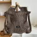 Detailed view of the coffee brown knitted pleated bag with unique woven texture and label - Wave Texture Style / Coffee