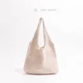 Detailweergave van de fijne ruitvormige breitextuur op deze stijlvolle off-white tas. - Beige
