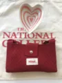Gedetailleerd overzicht van rode gebreide crossbody minitas met patroon en drukknop. - Bordeauxrood