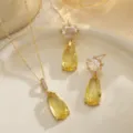 Close-up of vintage yellow teardrop zircon necklace and earrings set on a beige tray - Necklace and Earrings Set (10063+10356) / Gold with Yellow Gemstone