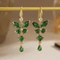 Detailed view of emerald green butterfly zircon earrings with gold finish and sparkling gems - Hollow Butterfly Style (80490) / Earrings / Gold Tone (Emerald Green Zirconia)