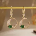 Detail view of crescent moon earrings featuring emerald green and white zircons. - Moon Shape Style (80494) / Earrings / Gold Tone (Emerald Green Zirconia)