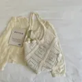 Bohemian cream large crochet hollow-out beach tote bag in a soft lifestyle setting - With Tulip Ornament (ZZB Diamond Pattern Bag) / Off White