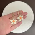Detailansicht eleganter Blumenohrringe mit weißen Blütenblättern und orangefarbenem Zentrum - Gold Beige Gänseblümchen (E5478) / Gold Beige