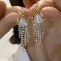 Detailed view of elegant gold-toned cat-eye stone earrings with sparkling rhinestone tassels. - Triangle Cat Eye Stone Pave Tassel Style (E3164) / Gold