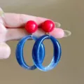 Detailed view of vibrant dopamine-style red stud earrings with blue resin oval drops - Ball and Oval Ring Geometric Style (E5029) / Red Blue