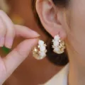 Close-up of elegant gold hoop earrings with white resin roses and sparkling crystals - Rose Hoop Earring (E5410) / White