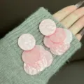 Elegant pink marbled acetate round cascading earrings displayed on a grey knit sleeve - Layered Disc Tassel Style (E4848) / Gold Pink