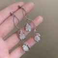 Close-up of French vintage style silver tassel earrings with white cat-eye stones - French Long Cat Eye Stone Tassel Silver Style (E0115)